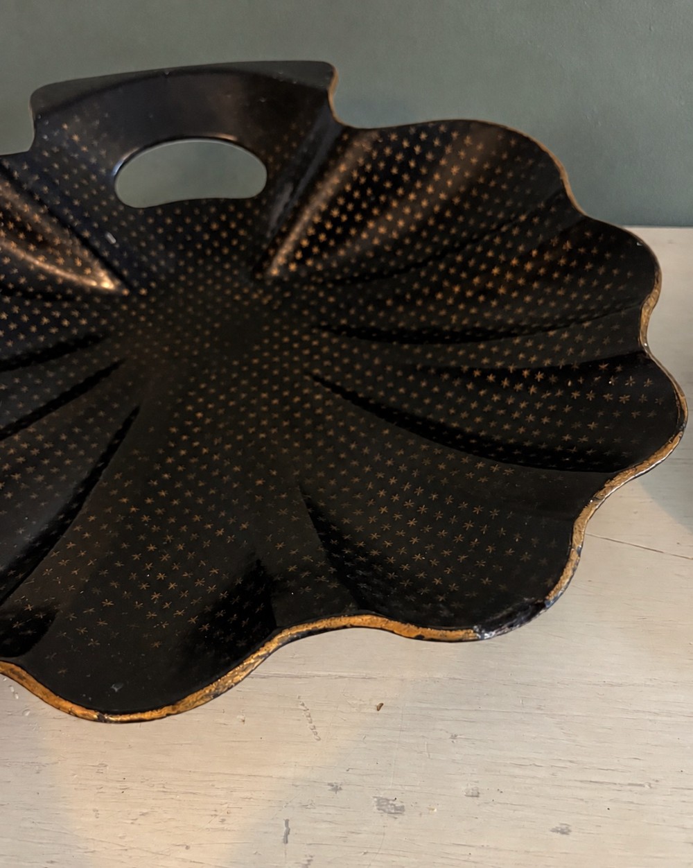A pair of black lacquered shell-shaped trays decorated with a gold star pattern, fluted edges, and integrated cut-out handles. View VI