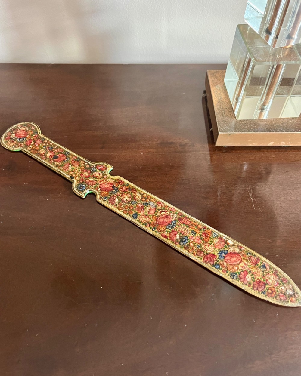 A 19th-century Kashmiri papier-mache letter opener featuring dense hand-painted polychrome floral decoration and gold detailing over a dark lacquered surface. View IV