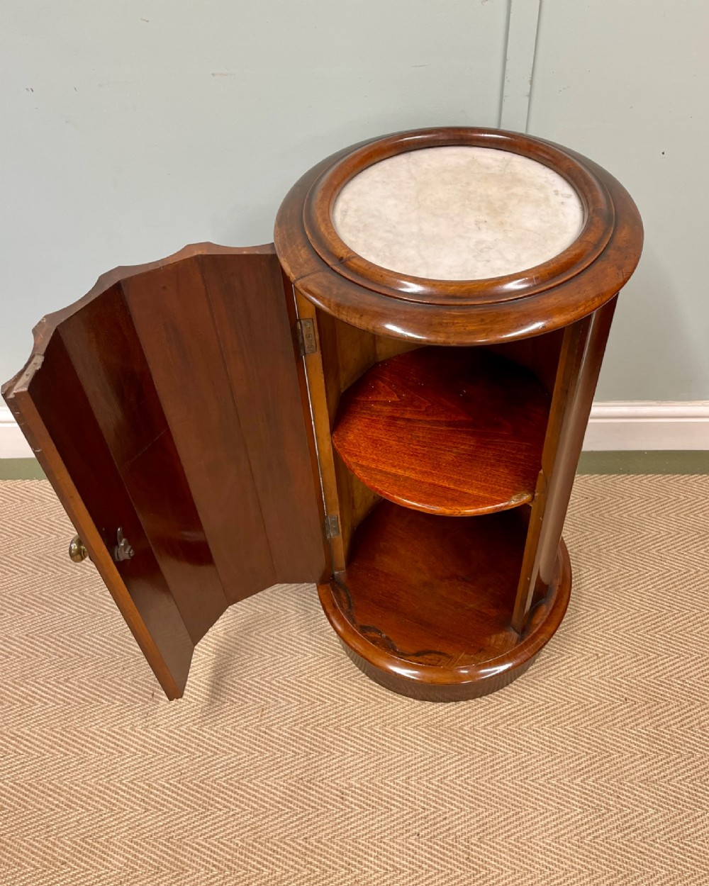 A 19th-century cylindrical dark mahogany pot cupboard featuring vertical fluting, a circular inset marble top, a single curved door, and a brass knob. View IV