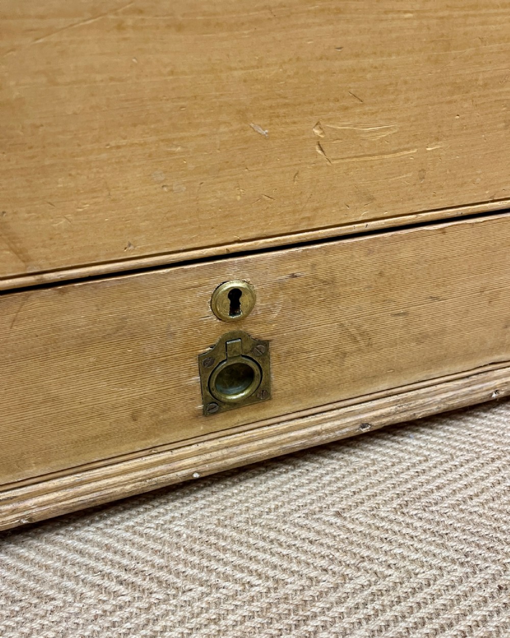 A 19th-century natural pine mule chest featuring a hinged top lid and two bottom drawers fitted with brass keyhole escutcheons. View VI