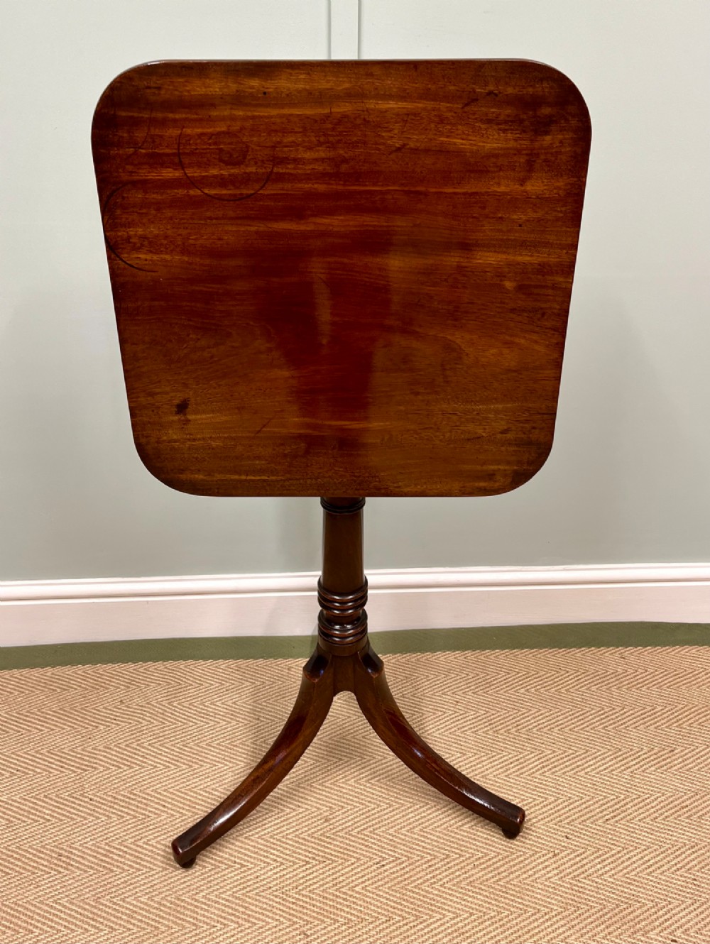A 19th-century mahogany snap-top side table featuring a square top with rounded corners, a turned central column, and three splayed legs. View III