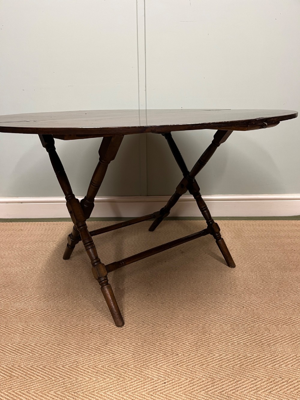 A circular 19th-century mahogany coaching table featuring a central hinged seam and brass hardware on turned legs. View III