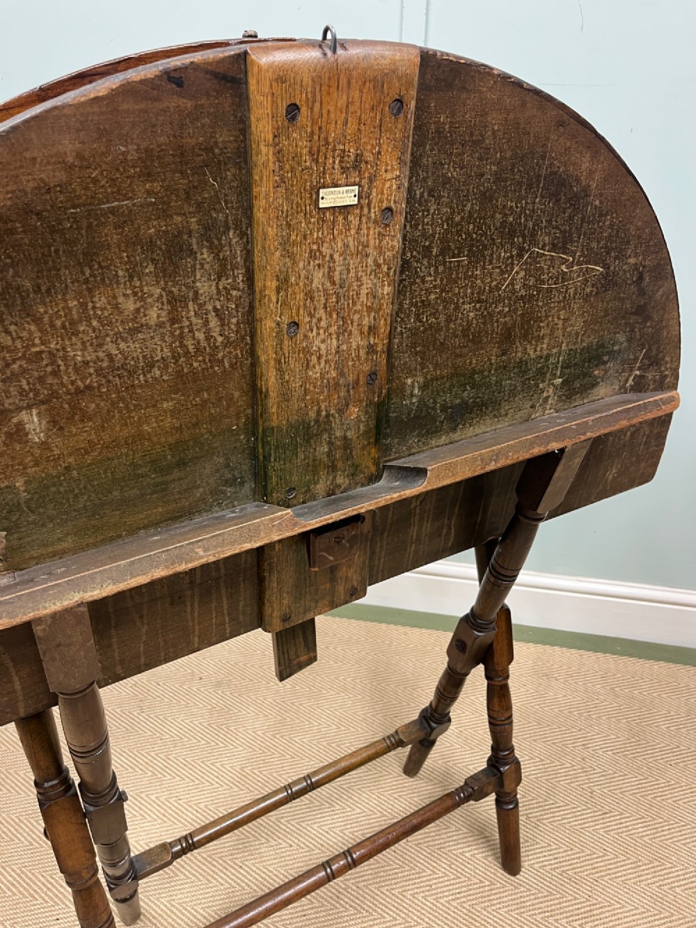 A circular 19th-century mahogany coaching table featuring a central hinged seam and brass hardware on turned legs. View VI