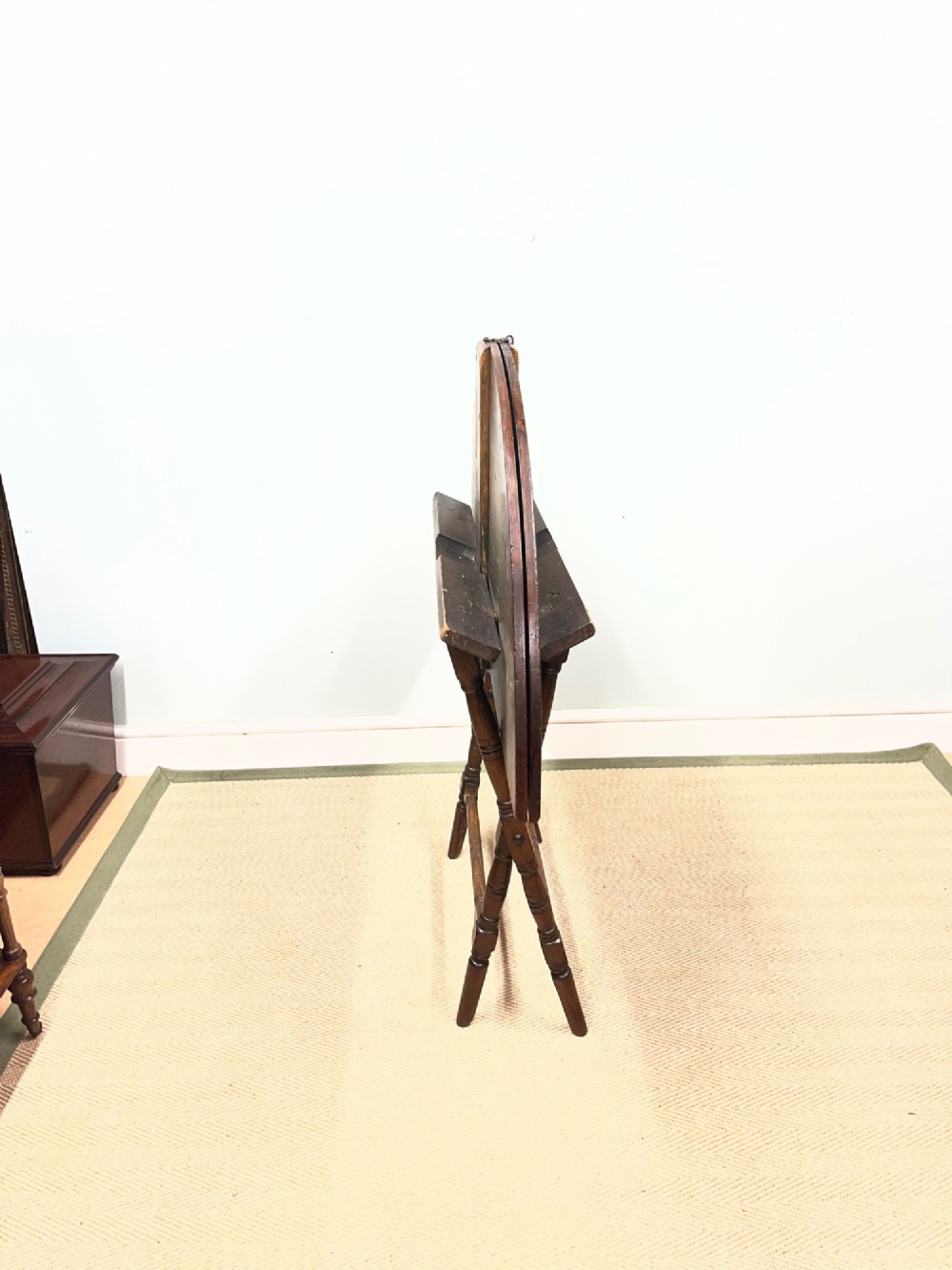A circular 19th-century mahogany coaching table featuring a central hinged seam and brass hardware on turned legs. View IX