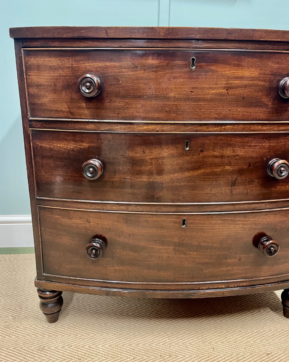 A 19th-century mahogany bowfront chest of drawers featuring three graduated drawers with turned wooden handles. View III