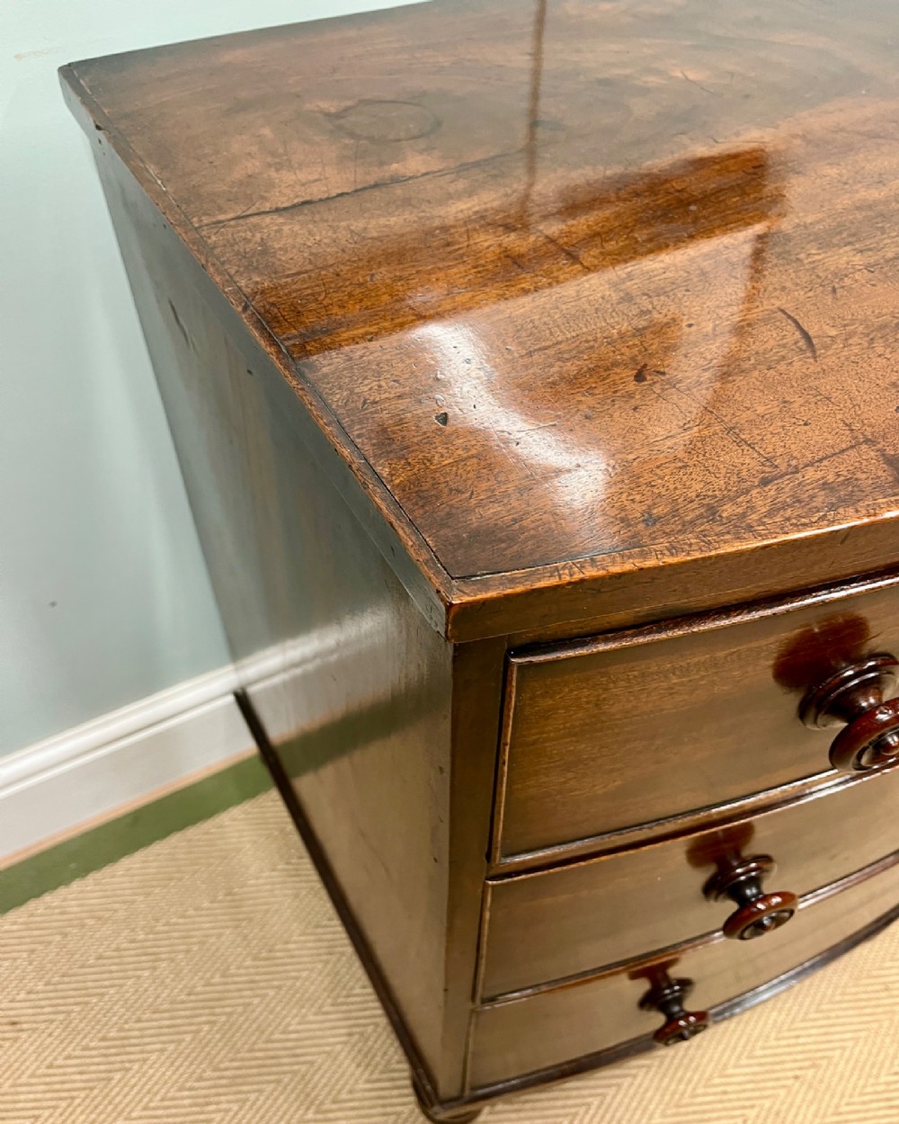 A 19th-century mahogany bowfront chest of drawers featuring three graduated drawers with turned wooden handles. View IV