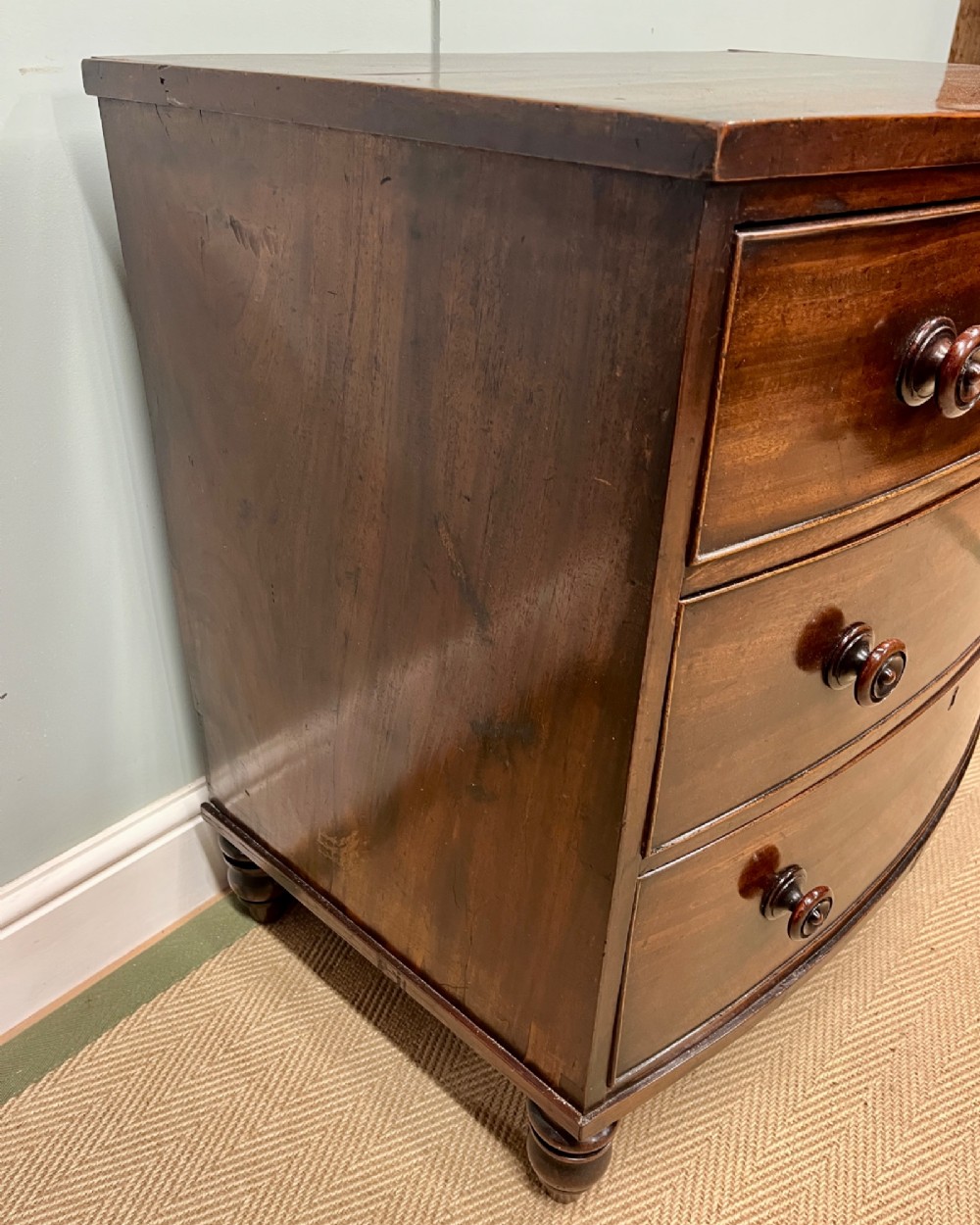 A 19th-century mahogany bowfront chest of drawers featuring three graduated drawers with turned wooden handles. View V
