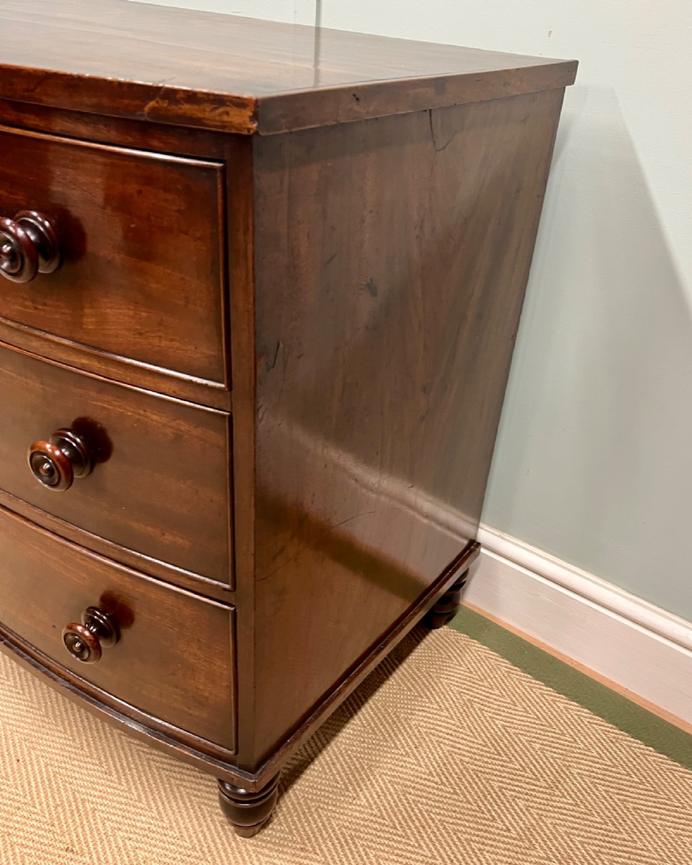 A 19th-century mahogany bowfront chest of drawers featuring three graduated drawers with turned wooden handles. View VI
