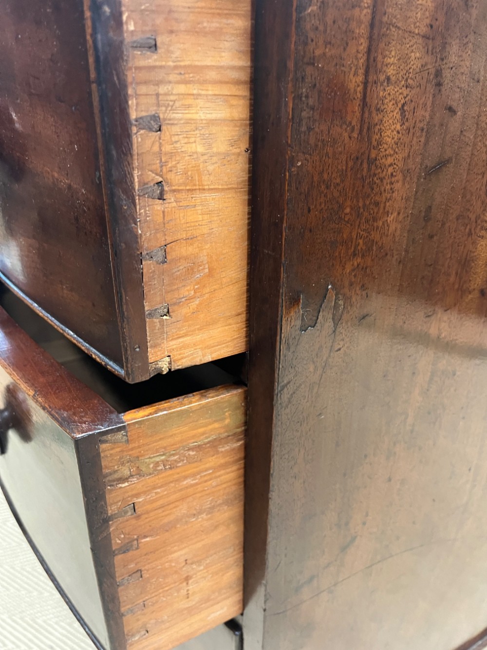 A 19th-century mahogany bowfront chest of drawers featuring three graduated drawers with turned wooden handles. View X