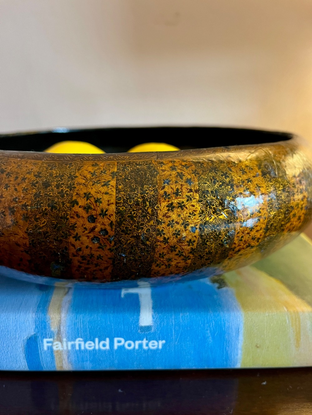A shallow rounded 19th-century Kashmiri bowl decorated with vertical gold and black floral lacquer patterns and a dark lacquered interior. View II