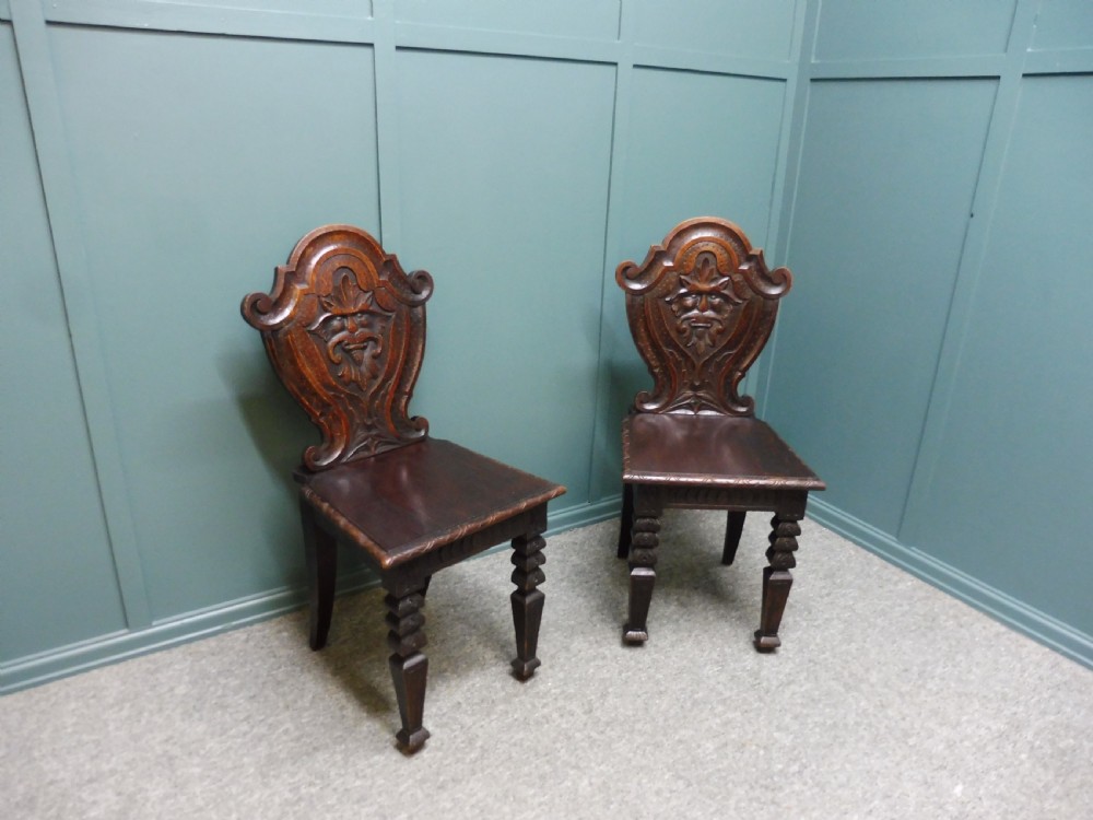 A PAIR OF 19TH CENTURY GREEN MAN HALL CHAIRS