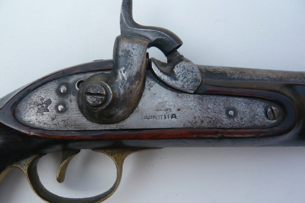 A 19th-century military percussion pistol featuring a dark hardwood stock, steel barrel, lockplate mechanism, brass trigger guard, and captive ramrod. View II