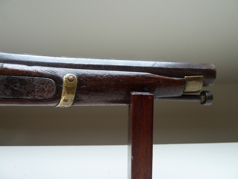 A 19th-century single-barrel percussion cap pistol featuring a dark wood stock, steel lock mechanism, and brass mountings. View III