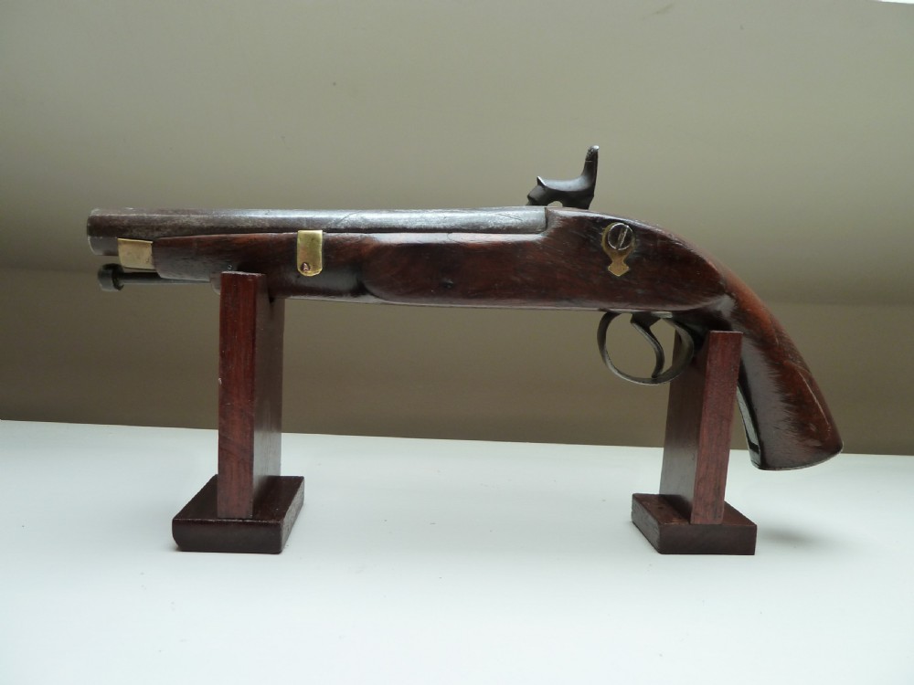 A 19th-century single-barrel percussion cap pistol featuring a dark wood stock, steel lock mechanism, and brass mountings. View V