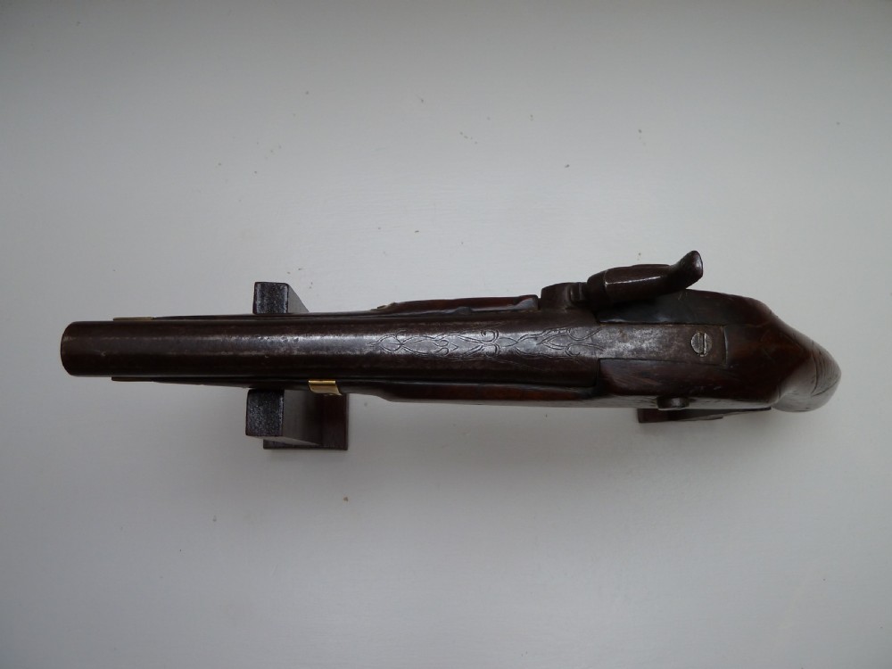 A 19th-century single-barrel percussion cap pistol featuring a dark wood stock, steel lock mechanism, and brass mountings. View VII