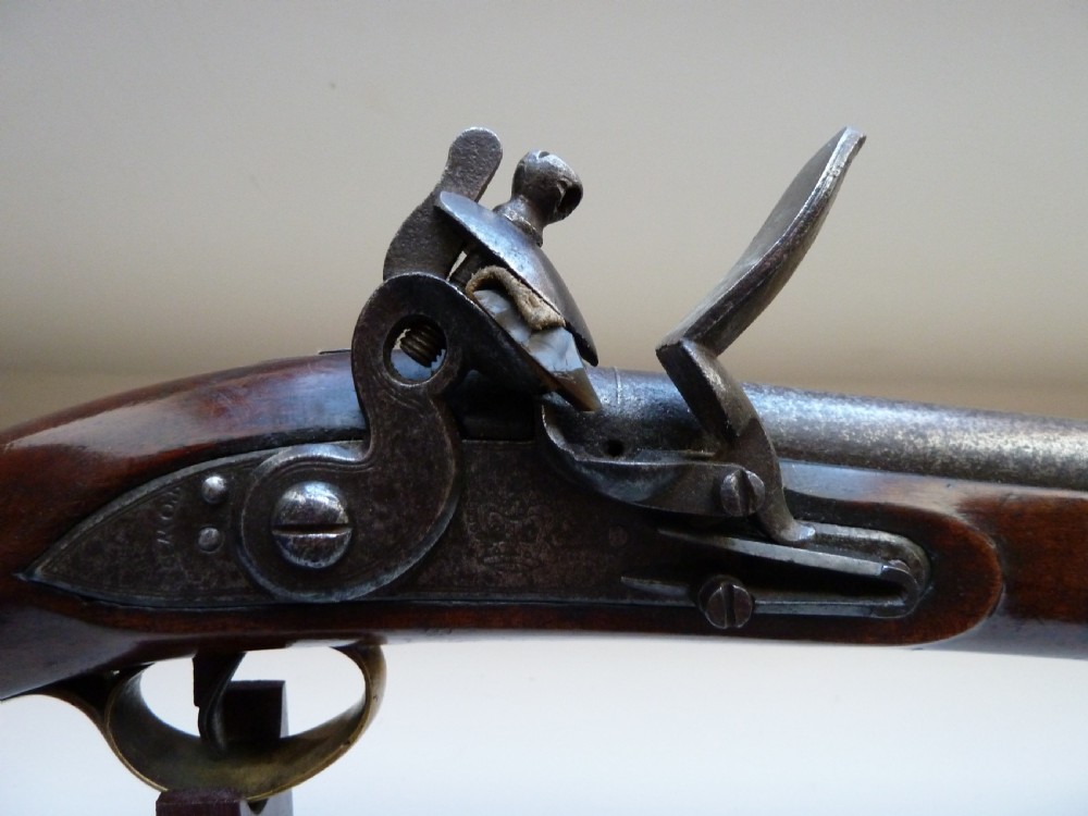 An antique British long-barrelled flintlock dragoon pistol featuring a polished walnut stock, steel barrel, steel lock mechanism, and brass fittings. View II