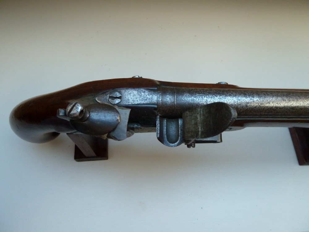 An antique British long-barrelled flintlock dragoon pistol featuring a polished walnut stock, steel barrel, steel lock mechanism, and brass fittings. View V