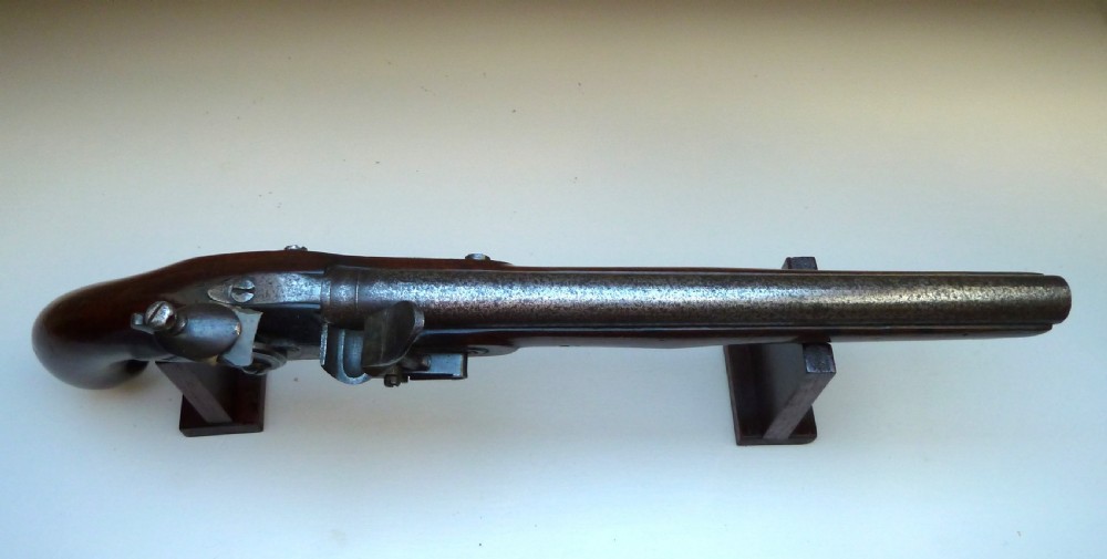An antique British long-barrelled flintlock dragoon pistol featuring a polished walnut stock, steel barrel, steel lock mechanism, and brass fittings. View VI