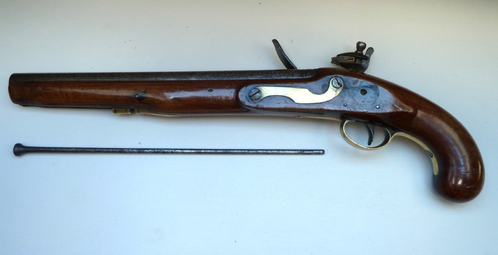 An antique British long-barrelled flintlock dragoon pistol featuring a polished walnut stock, steel barrel, steel lock mechanism, and brass fittings. View X