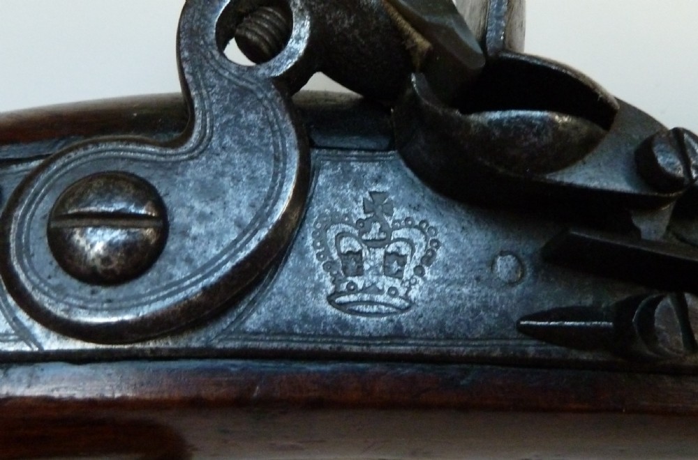 An antique British long-barrelled flintlock dragoon pistol featuring a polished walnut stock, steel barrel, steel lock mechanism, and brass fittings. View XII