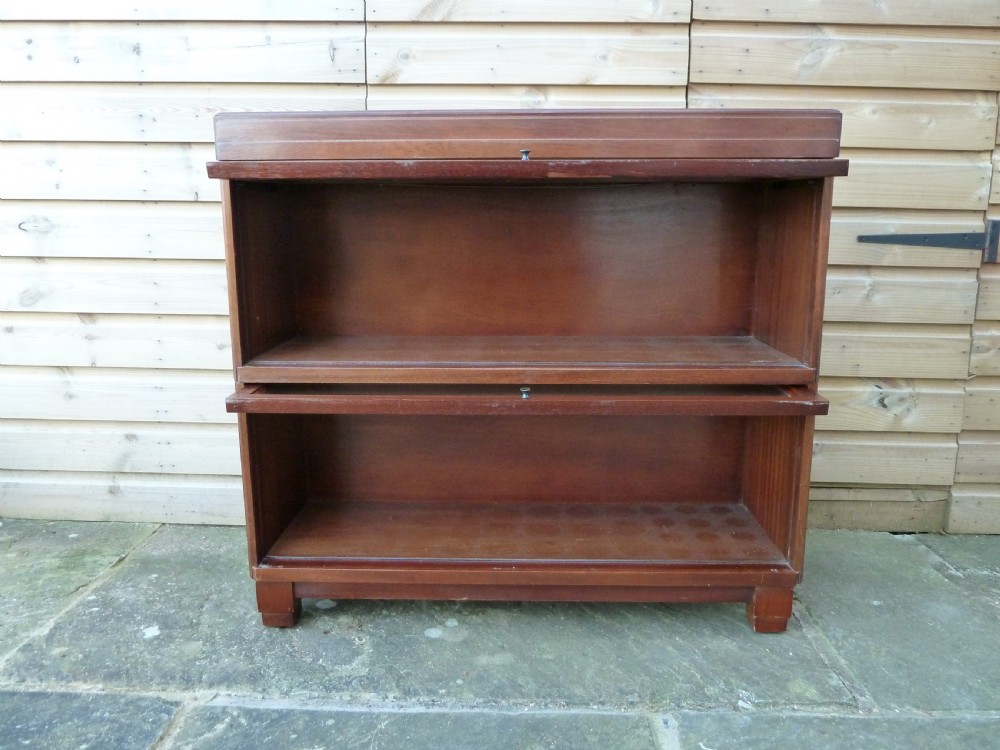 An Art Deco two-tier modular wood sectional bookcase featuring glass up-and-over doors and square block feet. View X