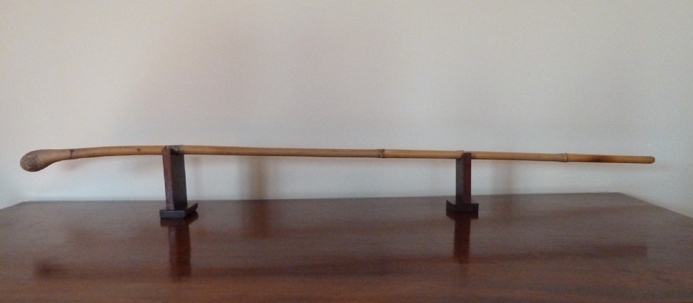 An antique bamboo swordstick shown partially unsheathed to reveal a concealed steel blade, featuring a natural bamboo handle and metal collar band. View II