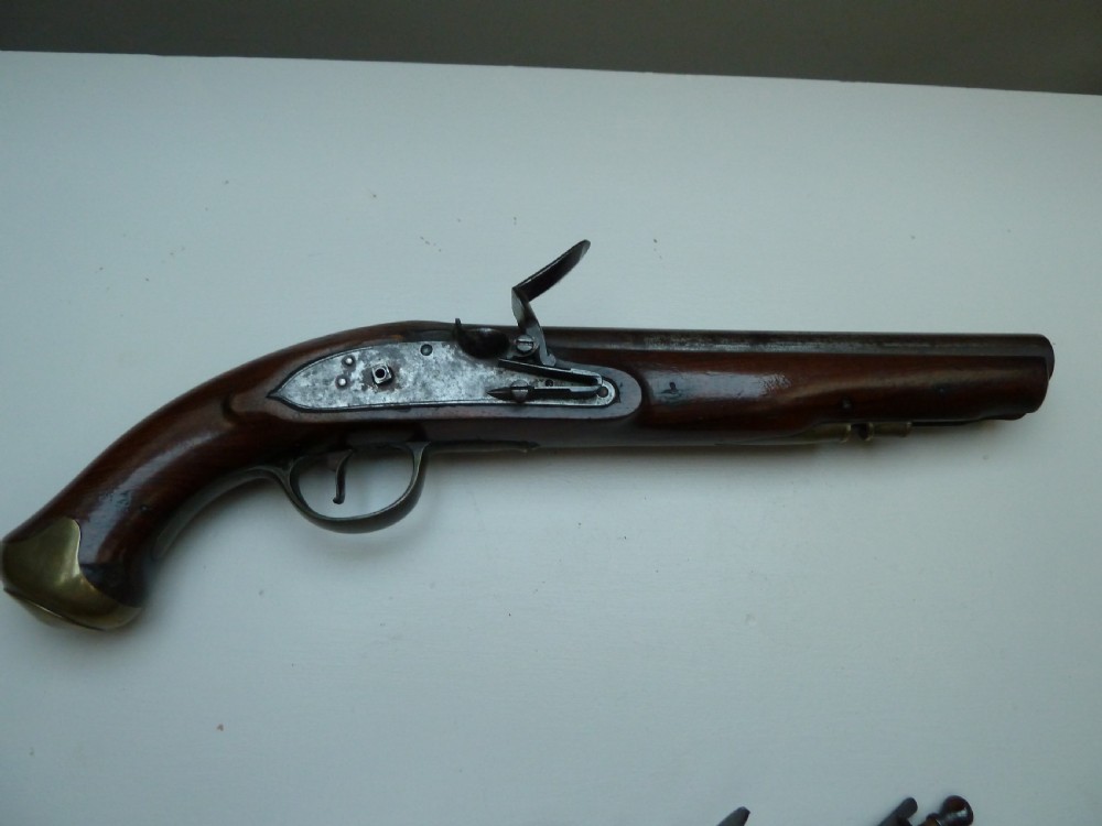 A pair of early 19th-century flintlock duelling pistols featuring contoured wooden stocks, brass sideplates, and steel barrels. View II