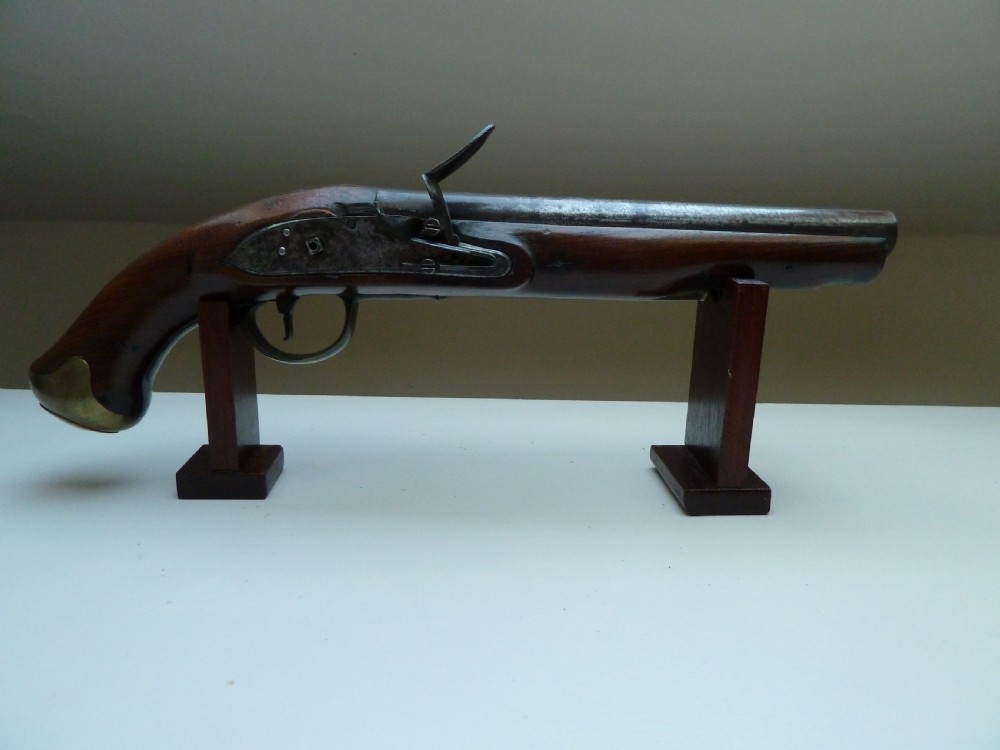 A pair of early 19th-century flintlock duelling pistols featuring contoured wooden stocks, brass sideplates, and steel barrels. View III