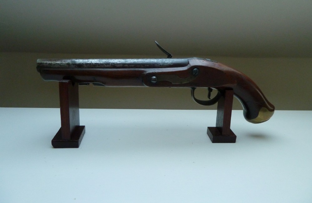 A pair of early 19th-century flintlock duelling pistols featuring contoured wooden stocks, brass sideplates, and steel barrels. View V