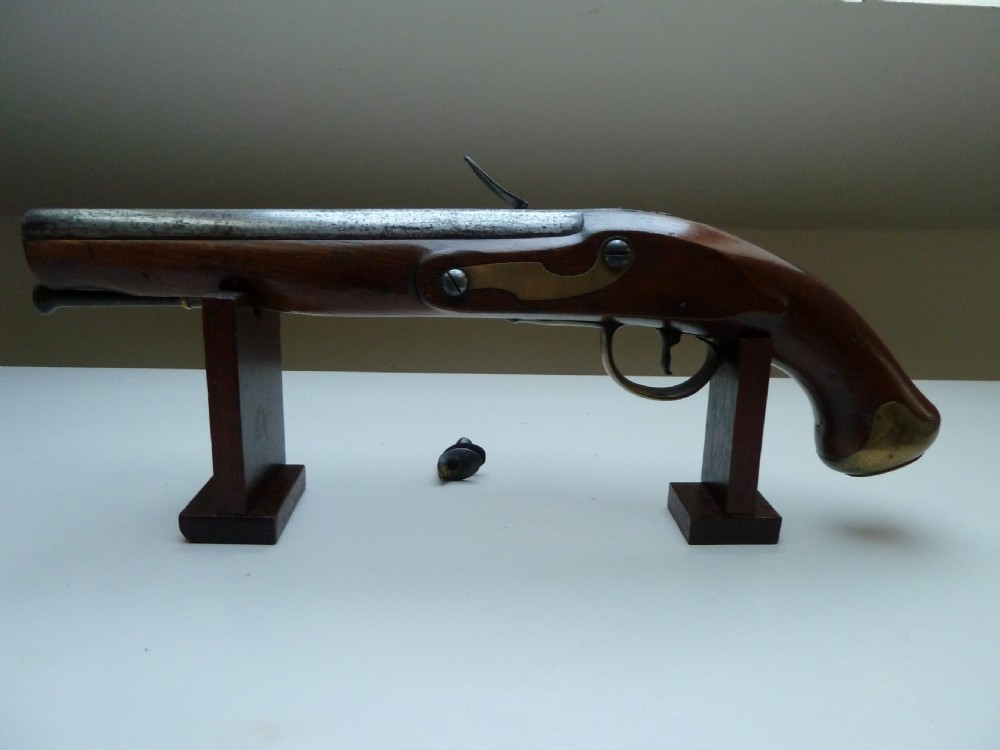 A pair of early 19th-century flintlock duelling pistols featuring contoured wooden stocks, brass sideplates, and steel barrels. View X