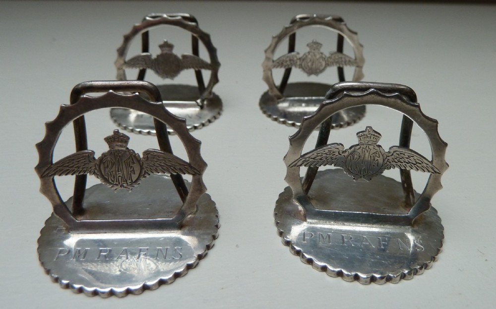 Set of four silver RAF menu holders featuring Royal Air Force wings and crown motifs on scalloped circular bases. View III