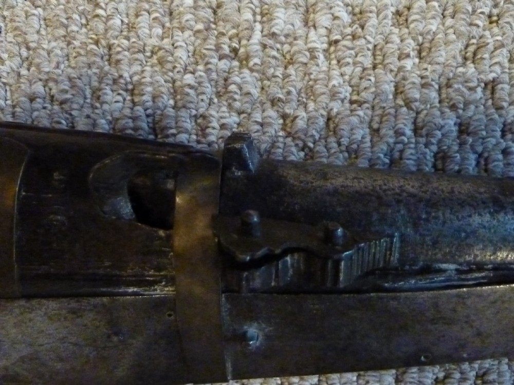 An antique Indian matchlock Torador musket featuring a long steel barrel bound with brass straps to a dark wood stock. View VI
