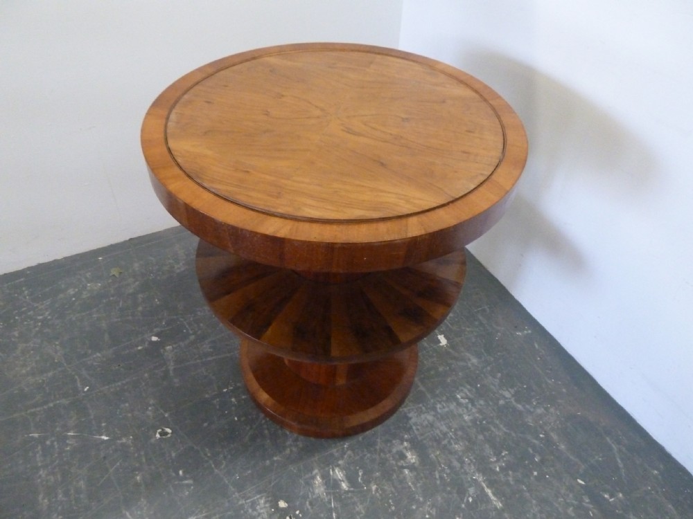 A circular Art Deco walnut metamorphic card table featuring a quarter-veneered top, central cylindrical column, and tiered circular shelf. View VII