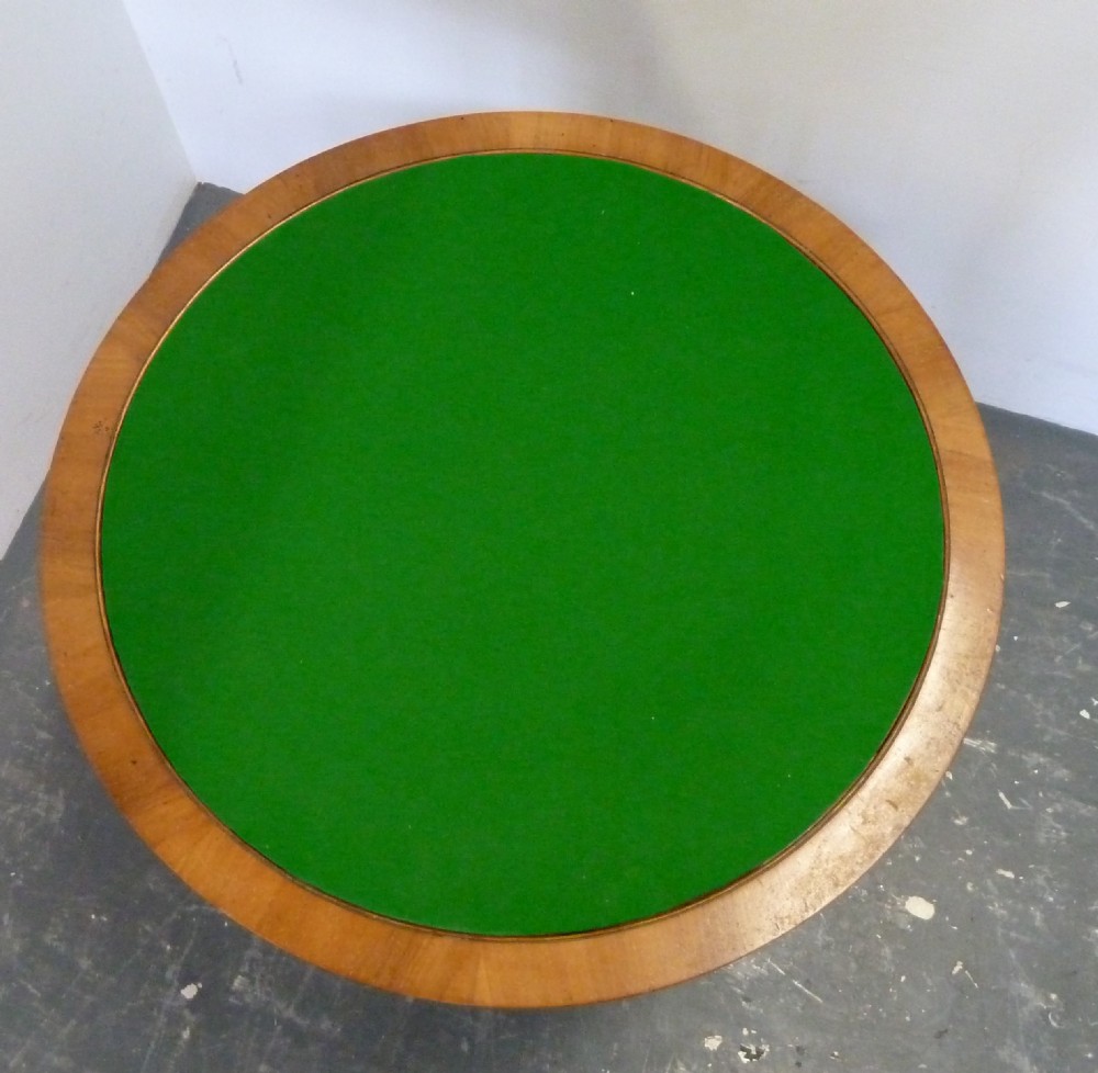 A circular Art Deco walnut metamorphic card table featuring a quarter-veneered top, central cylindrical column, and tiered circular shelf. View VIII