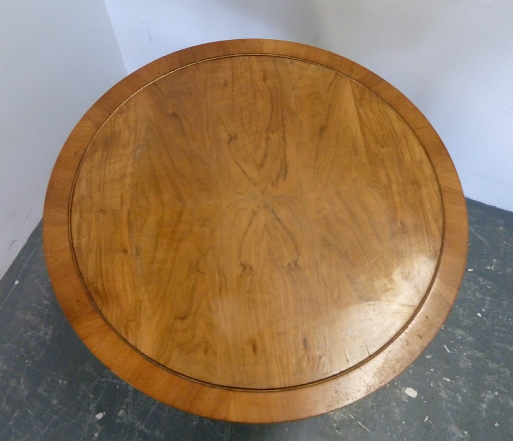 A circular Art Deco walnut metamorphic card table featuring a quarter-veneered top, central cylindrical column, and tiered circular shelf. View IX
