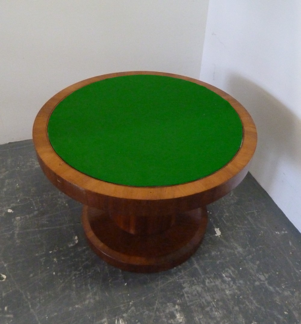 A circular Art Deco walnut metamorphic card table featuring a quarter-veneered top, central cylindrical column, and tiered circular shelf. View XI
