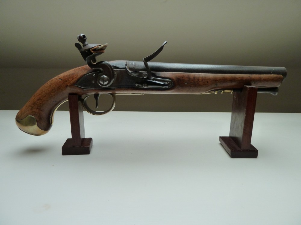 An 18th-century flintlock pistol featuring a carved dark walnut stock, a steel barrel and flint mechanism, and a brass butt cap. View II