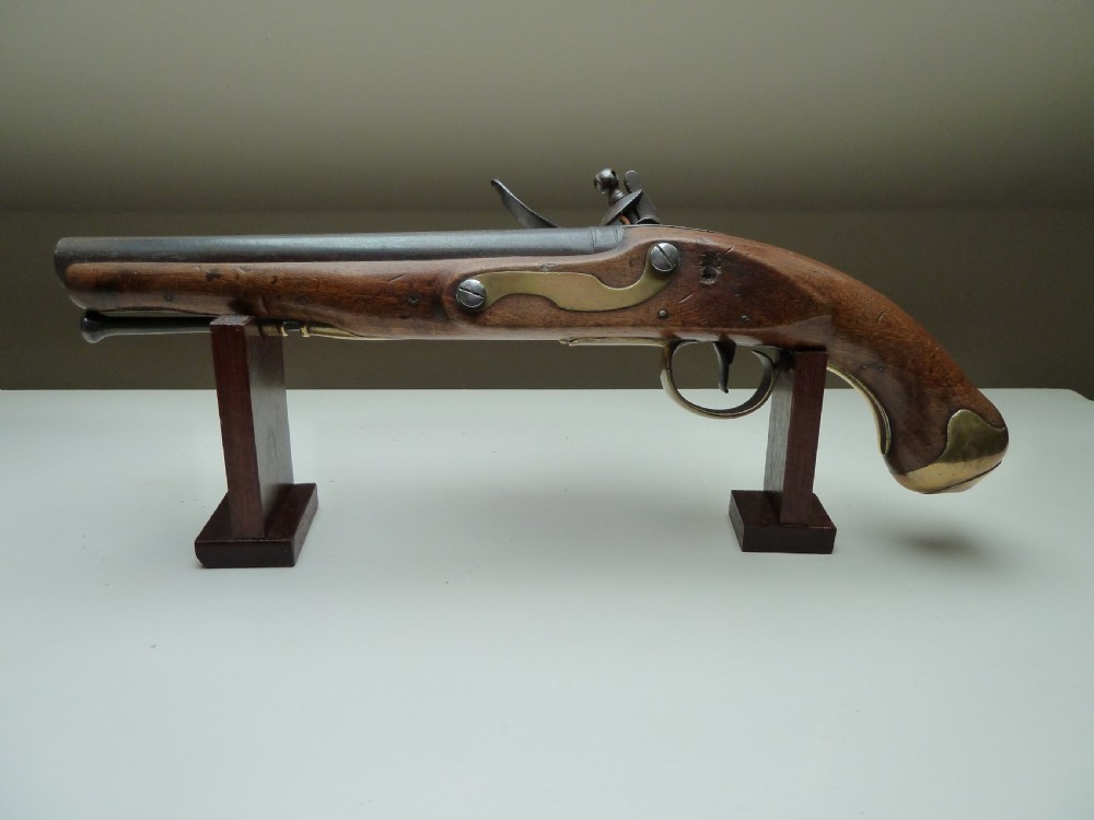 An 18th-century flintlock pistol featuring a carved dark walnut stock, a steel barrel and flint mechanism, and a brass butt cap. View III