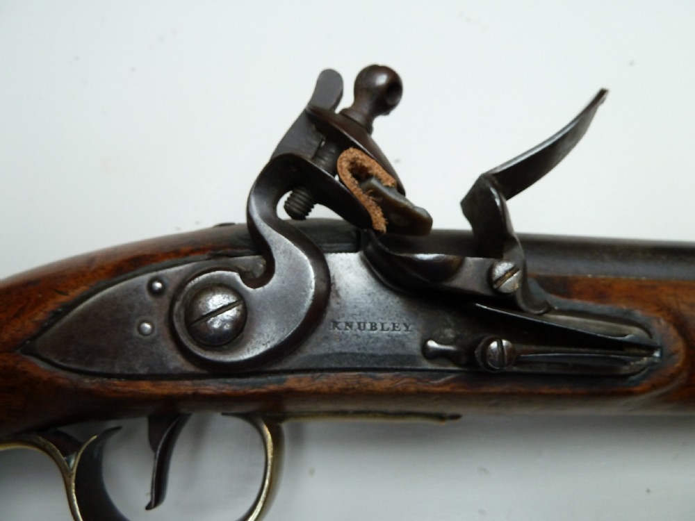 An 18th-century flintlock pistol featuring a carved dark walnut stock, a steel barrel and flint mechanism, and a brass butt cap. View VII