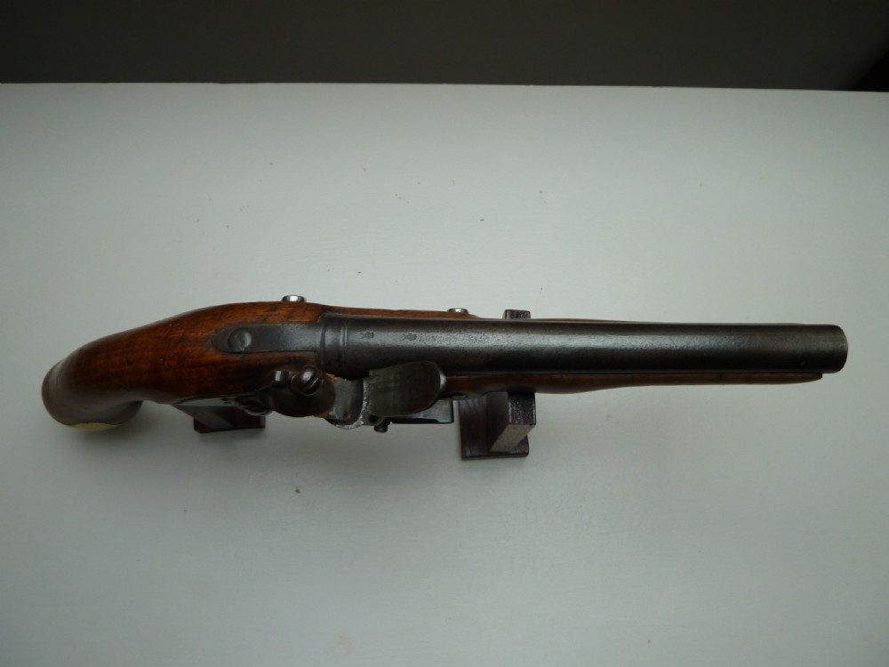 An 18th-century flintlock pistol featuring a carved dark walnut stock, a steel barrel and flint mechanism, and a brass butt cap. View VIII