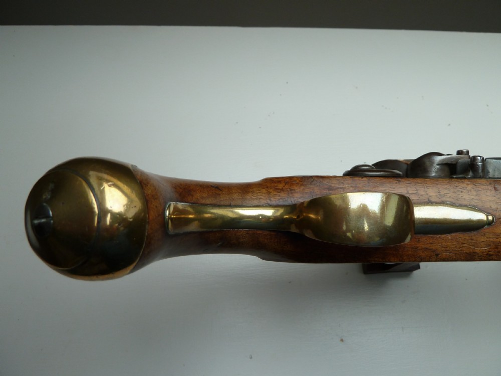 An 18th-century flintlock pistol featuring a carved dark walnut stock, a steel barrel and flint mechanism, and a brass butt cap. View XI