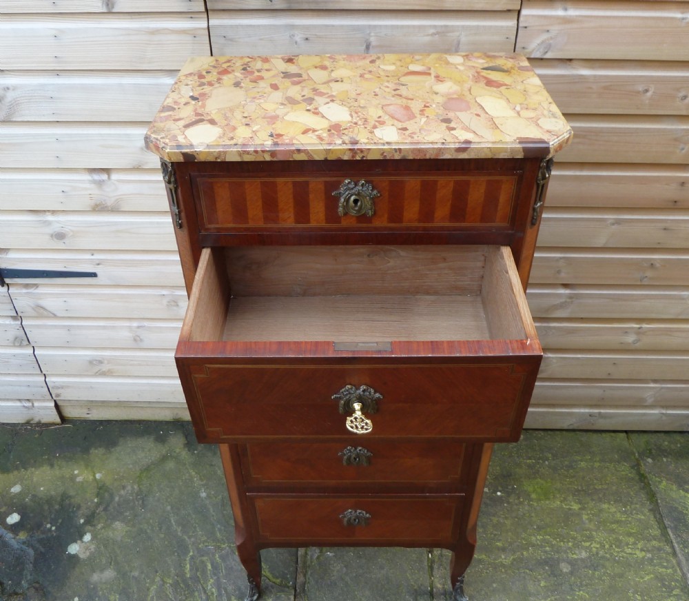 A tall French semainier chest of drawers featuring five inlaid timber drawers, bronze escutcheons, cabriole legs, and a marble top. View VII