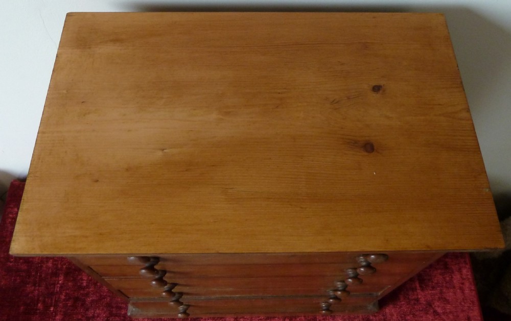 A Victorian pine chest featuring six shallow drawers with turned wooden knobs and a solid plinth base. View II