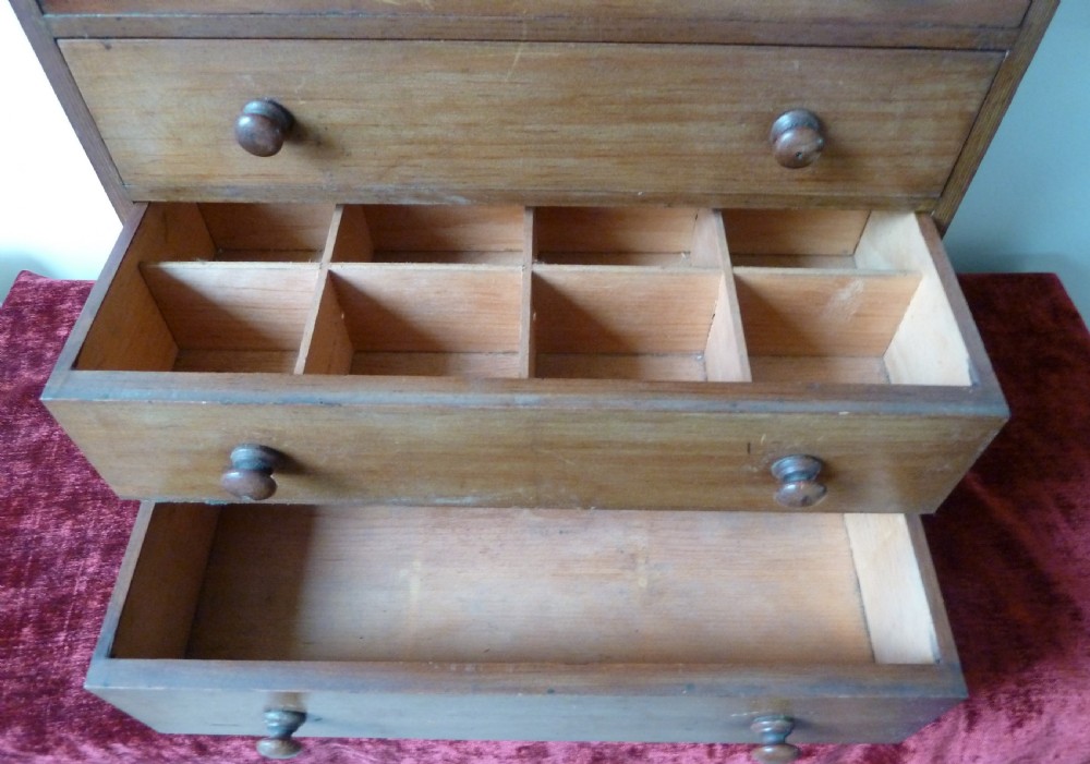 A Victorian pine chest featuring six shallow drawers with turned wooden knobs and a solid plinth base. View VII