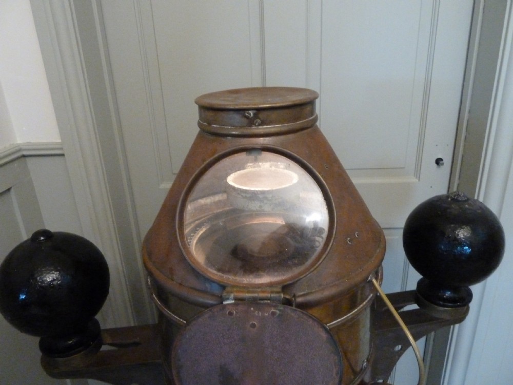 A 19th-century floor-standing ships binnacle featuring a polished brass hood with a glass viewing window, a wooden cylindrical pedestal, and two black iron spheres mounted on side brackets. View VII