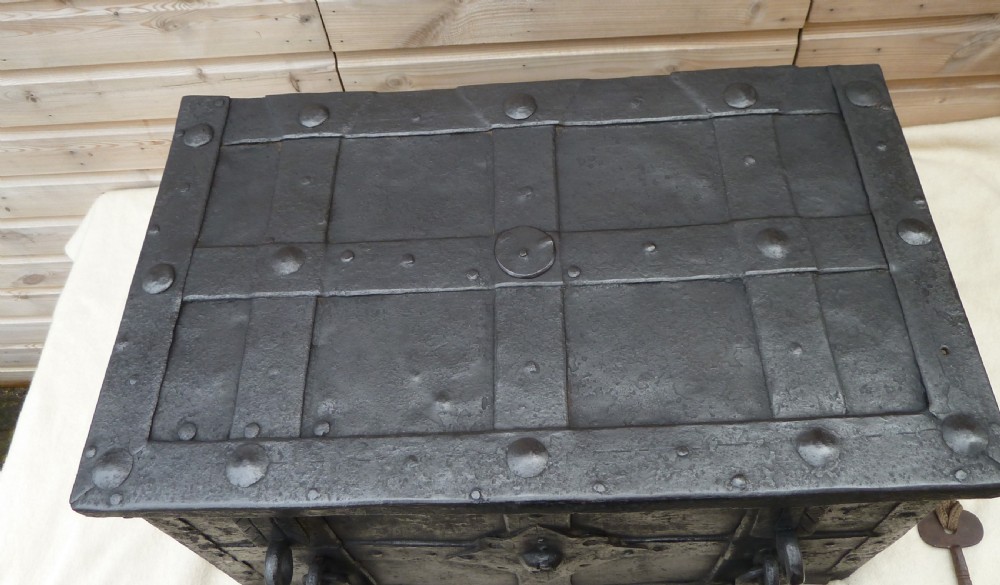 A heavy 17th-century black wrought iron Armada chest with external iron strapwork, side drop handles, and a key sticking out from the top lid. View III