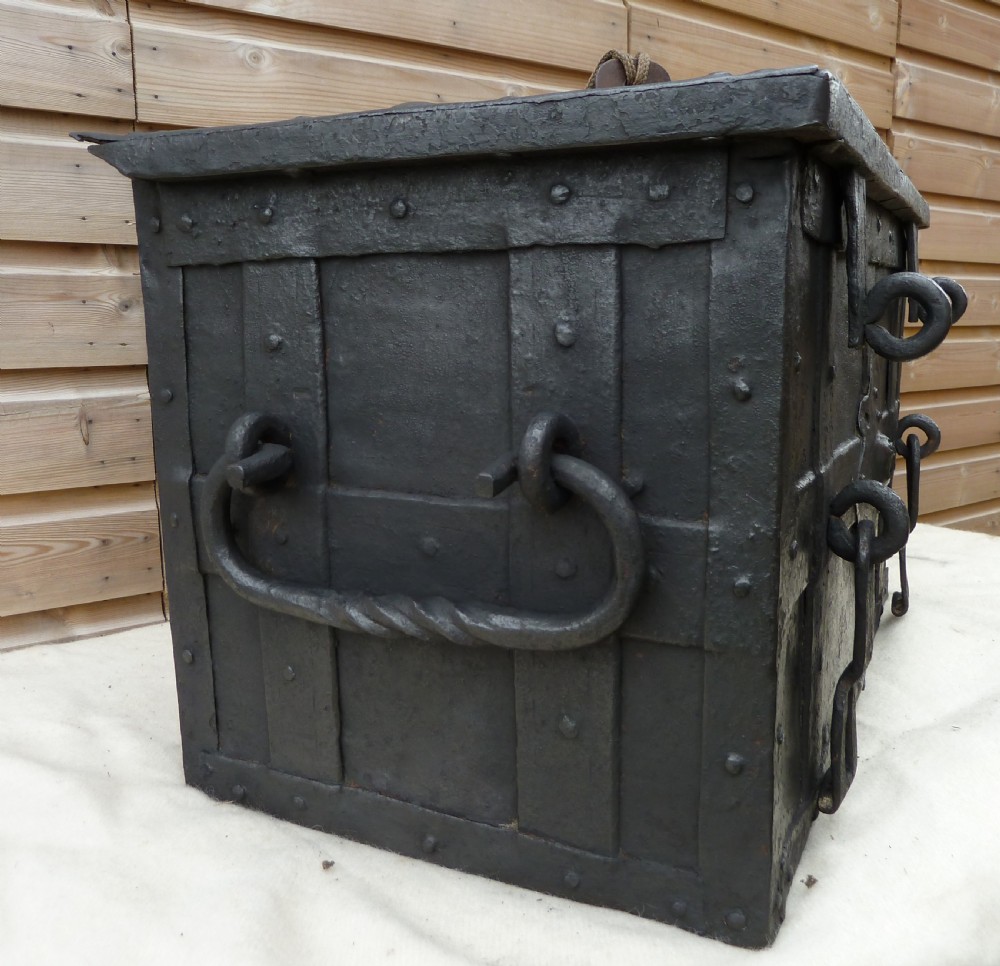 A heavy 17th-century black wrought iron Armada chest with external iron strapwork, side drop handles, and a key sticking out from the top lid. View XII