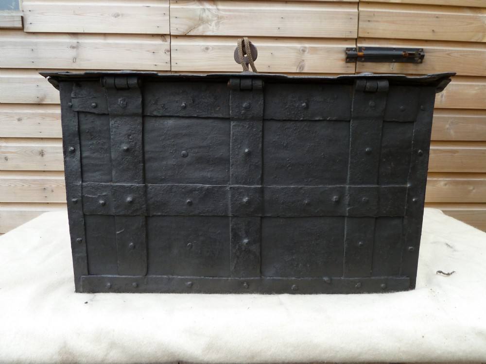 A heavy 17th-century black wrought iron Armada chest with external iron strapwork, side drop handles, and a key sticking out from the top lid. View XIV