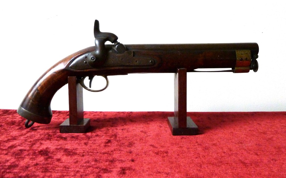 An antique 19th-century East India Company percussion pistol with a dark walnut stock, steel barrel and lock, brass trigger guard, and captive swivel ramrod.