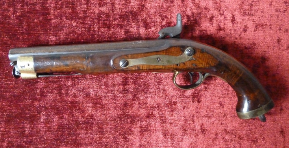 An antique 19th-century East India Company percussion pistol with a dark walnut stock, steel barrel and lock, brass trigger guard, and captive swivel ramrod. View IX